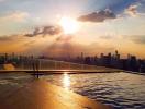 Rooftop swimming pool with sunset and city skyline view