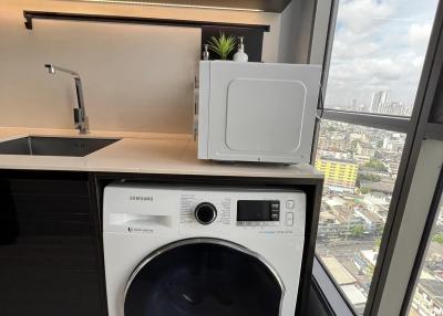 Compact laundry area with modern washing machine and city view