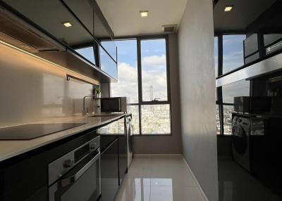 Modern kitchen with sleek black cabinets, large windows, and high-end appliances