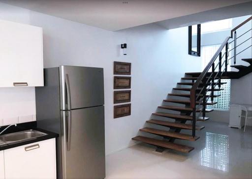 Modern kitchen with stainless steel appliances and staircase