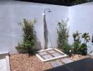 Outdoor shower area with stone pathway and small surrounding garden