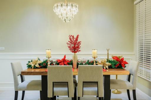 Elegant dining room with a festive centerpiece and modern chandelier