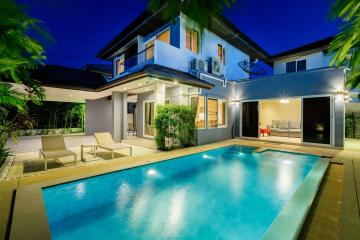 Elegant home exterior with a swimming pool at twilight