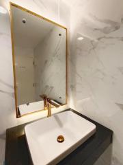 Modern bathroom with marble walls and gold accents