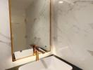 Modern bathroom with marble walls and gold accents