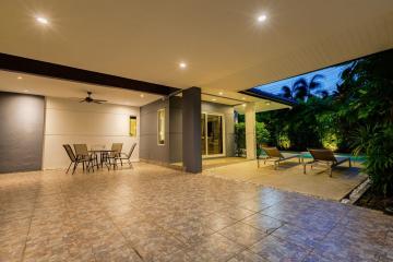 Spacious outdoor patio with dining area and poolside loungers