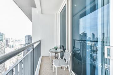 Modern balcony with city view featuring seating area and transparent railing