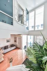 Modern double-height living room with a mezzanine and large windows