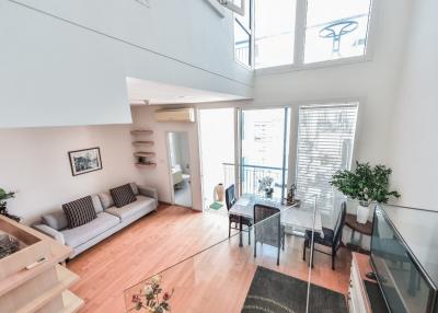 Spacious and bright two-level living room with high ceiling and large windows