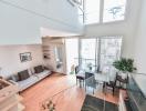 Spacious and bright two-level living room with high ceiling and large windows