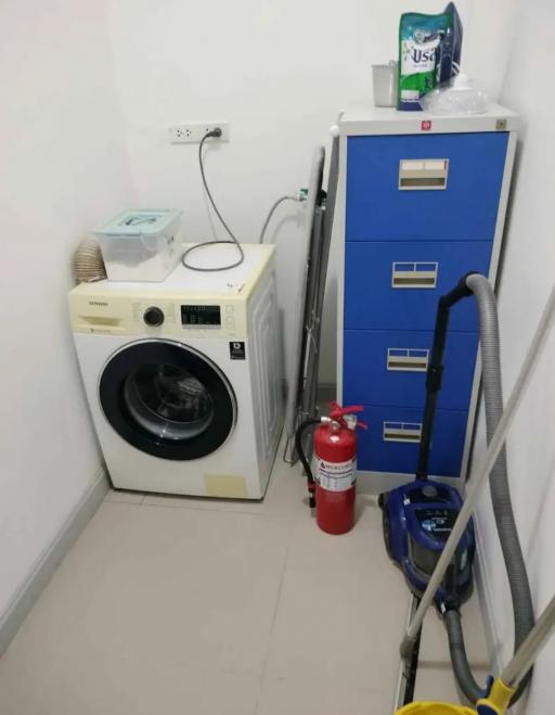 Compact laundry room with washing machine and storage facilities