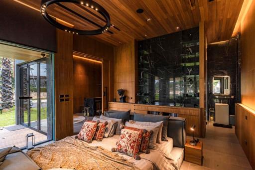 Modern bedroom with large bed, wood-paneled walls, and round ceiling light fixture