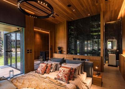 Modern bedroom with large bed, wood-paneled walls, and round ceiling light fixture
