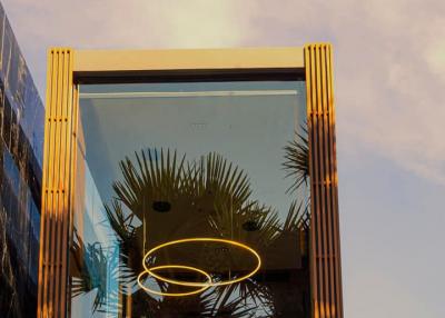 Modern building facade with gold accents and sky reflection