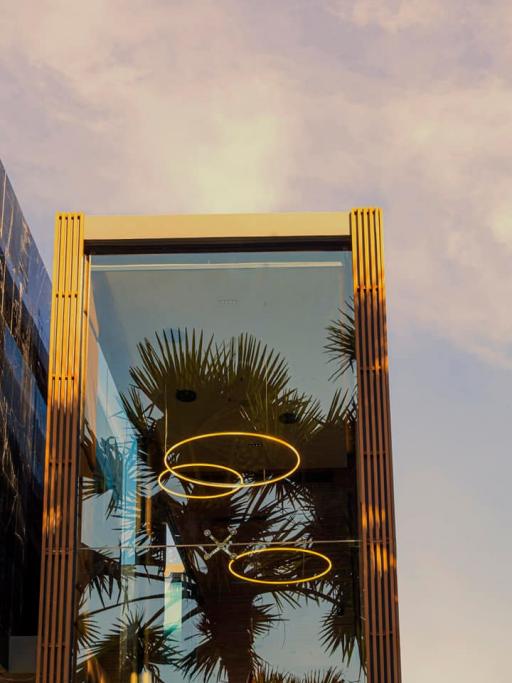 Modern building facade with gold accents and sky reflection