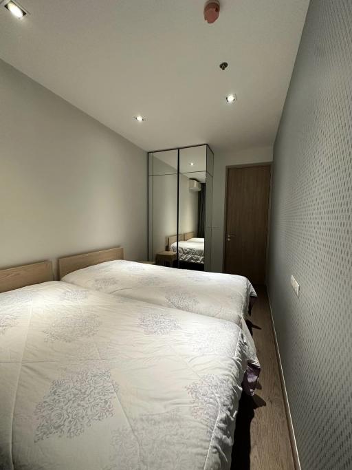 Modern bedroom with a large bed and mirrored wardrobe