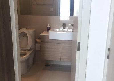 Modern bathroom interior with clear glass shower, vanity sink, and toilet