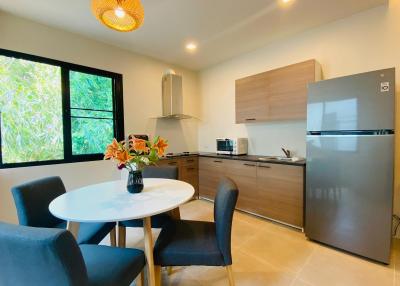 Modern kitchen with stainless steel appliances, wooden cabinets, and dining area