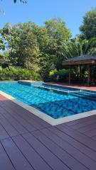 Private outdoor swimming pool with surrounding deck and garden gazebo