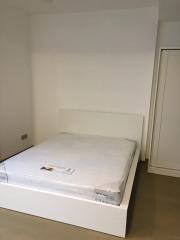 Minimalist bedroom with unmade bed and white walls