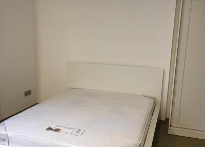 Minimalist bedroom with unmade bed and white walls