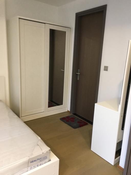 Compact bedroom with built-in closet and wooden door