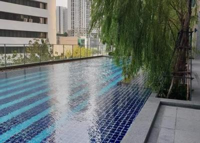 Swimming pool area adjacent to high-rise buildings with a view of the cityscape