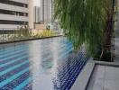 Swimming pool area adjacent to high-rise buildings with a view of the cityscape