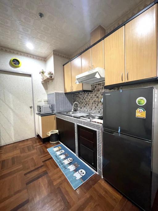 Modern compact kitchen with wooden cabinets and stainless steel appliances