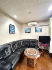 Spacious living room with leather sofa and modern amenities
