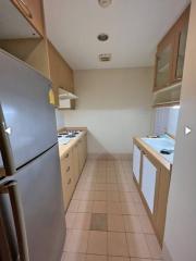 Galley kitchen with modern appliances and tiled flooring