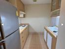 Galley kitchen with modern appliances and tiled flooring