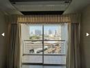 Spacious bedroom with a large window offering a city view