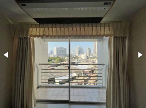 Spacious bedroom with a large window offering a city view