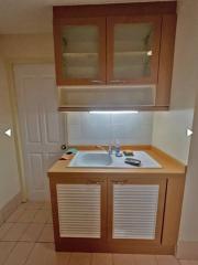 Compact kitchen with wooden cabinets and white appliances