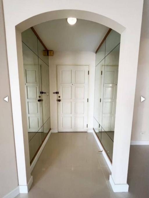 Bright and welcoming entrance hall with mirrors and tiled flooring