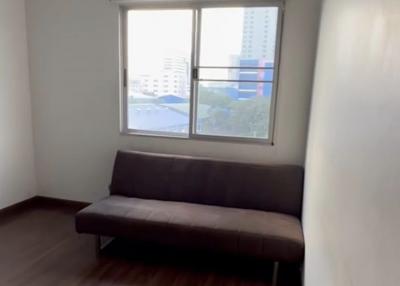 Minimalist living room with a large window and a dark sofa