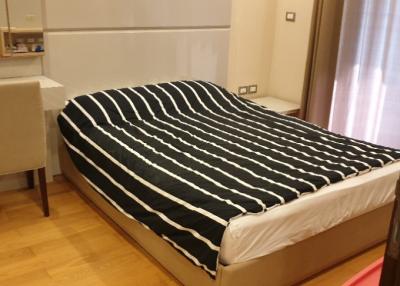 Cozy bedroom with striped bedding and wooden flooring