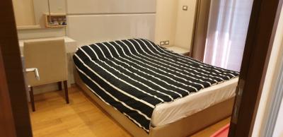 Cozy bedroom with striped bedding and wooden flooring