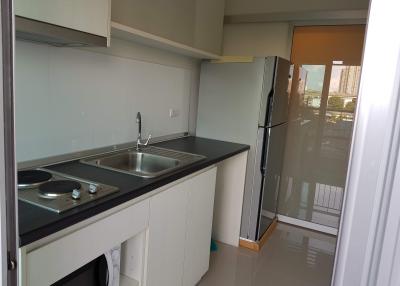 Compact kitchen with modern appliances and balcony access