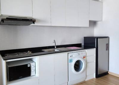 Modern kitchen with white cabinetry, appliances and washing machine