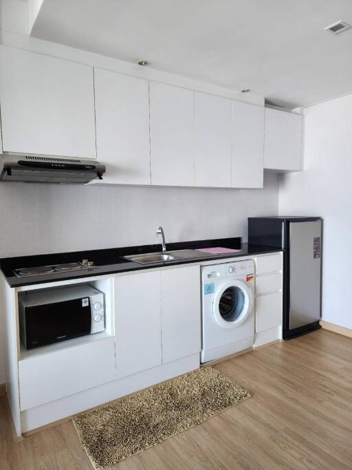 Modern kitchen with white cabinetry, appliances and washing machine