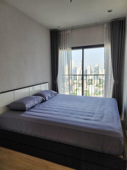 Modern bedroom with large window and city view