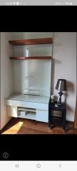 Cozy bedroom corner with a built-in desk and shelving, accompanied by a classic table lamp