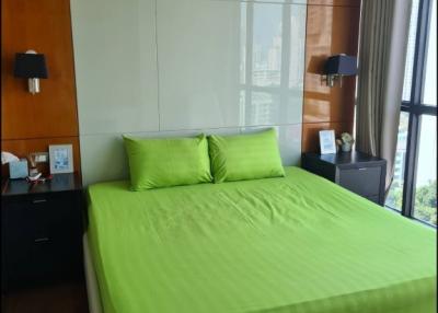 Modern bedroom with large window and green bedding