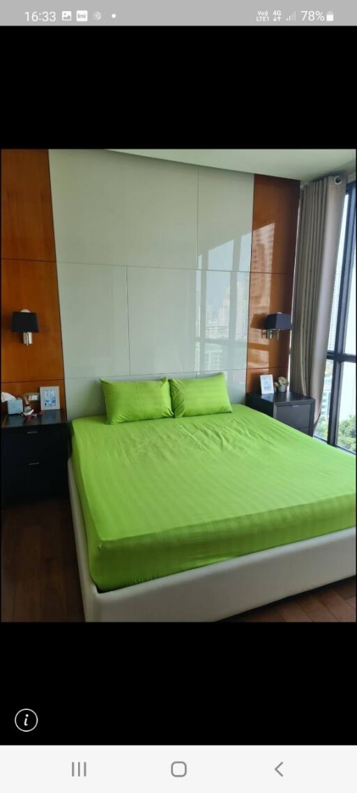 Modern bedroom with large window and green bedding