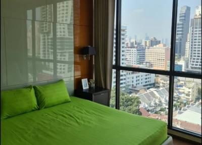 Modern bedroom with large window offering city views