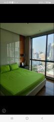 Modern bedroom with large window offering city views