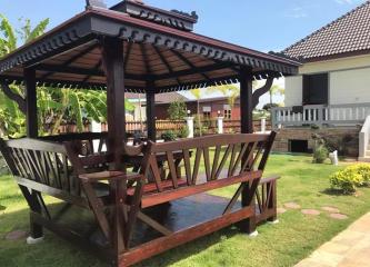 Spacious garden with a wooden gazebo and green lawn