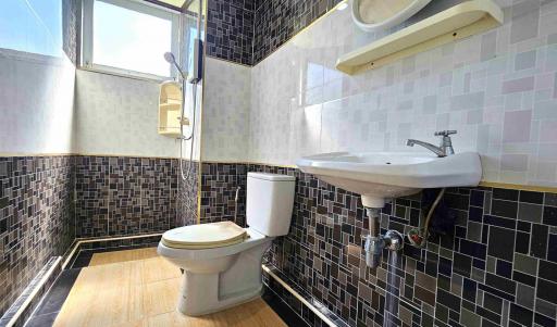 Modern bathroom with black tile design and natural light